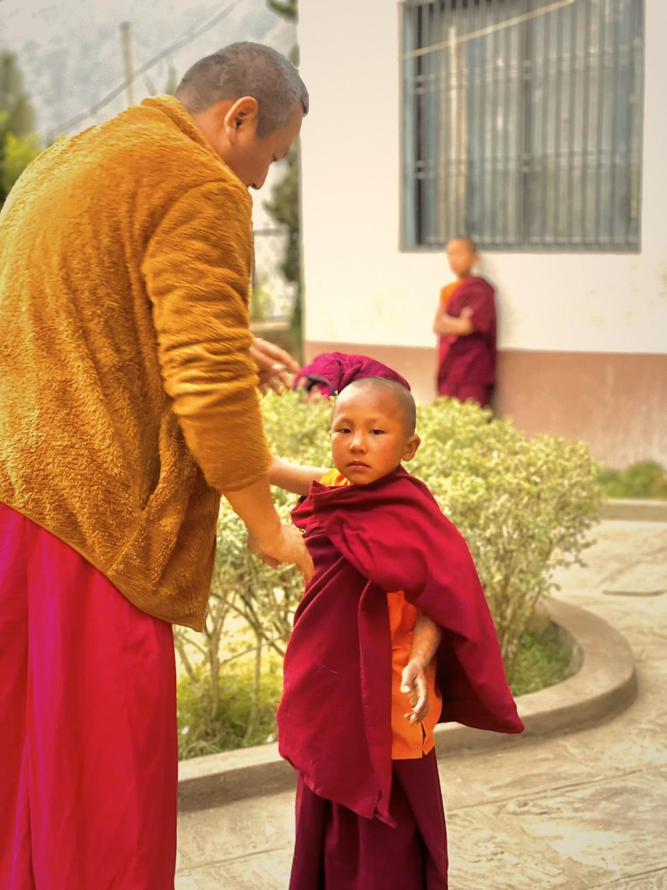 Rinpoche chỉnh lại y cho một chú tiểu
